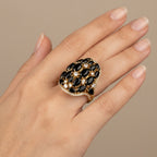Bague fleur en or jaune 18k pierres noires ovales serties - bijou porté par une mannequin
