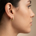 Boucles d'oreilles mini créoles en or jaune 18k serties de pierres - bijou porté par une mannequin