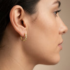 Boucles d'oreilles mini créoles en or jaune 18k serties de pierres - bijou porté par une mannequin