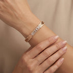 Bracelet jonc en or rose 18k pavé de pierres, motif plumes - bijou porté par une mannequin