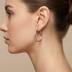 Boucles d'oreilles créoles fines en or rose 18k - bijou porté par une mannequin