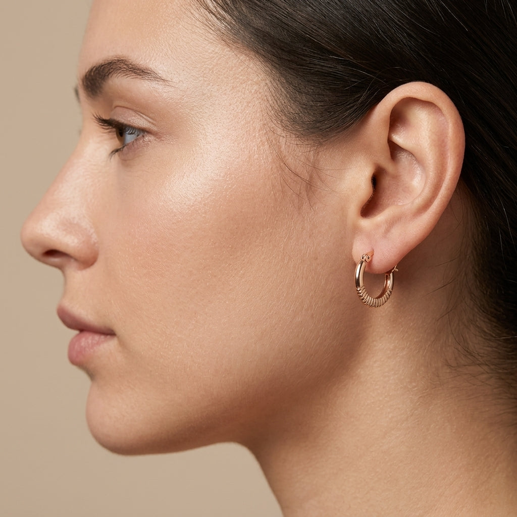 Boucles d'oreilles mini créoles ciselées en or rose 18k - bijou porté par une mannequin