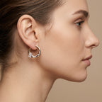 Boucles d'oreilles créoles en or rose et blanc 18k serties de pierres - bijou porté par une mannequin