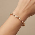 Bracelet jonc en or rose 18k boules et cubes - bijou porté par une mannequin