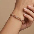 Bracelet jonc double barre en or rose 18k serti de pierres - bijou porté par une mannequin